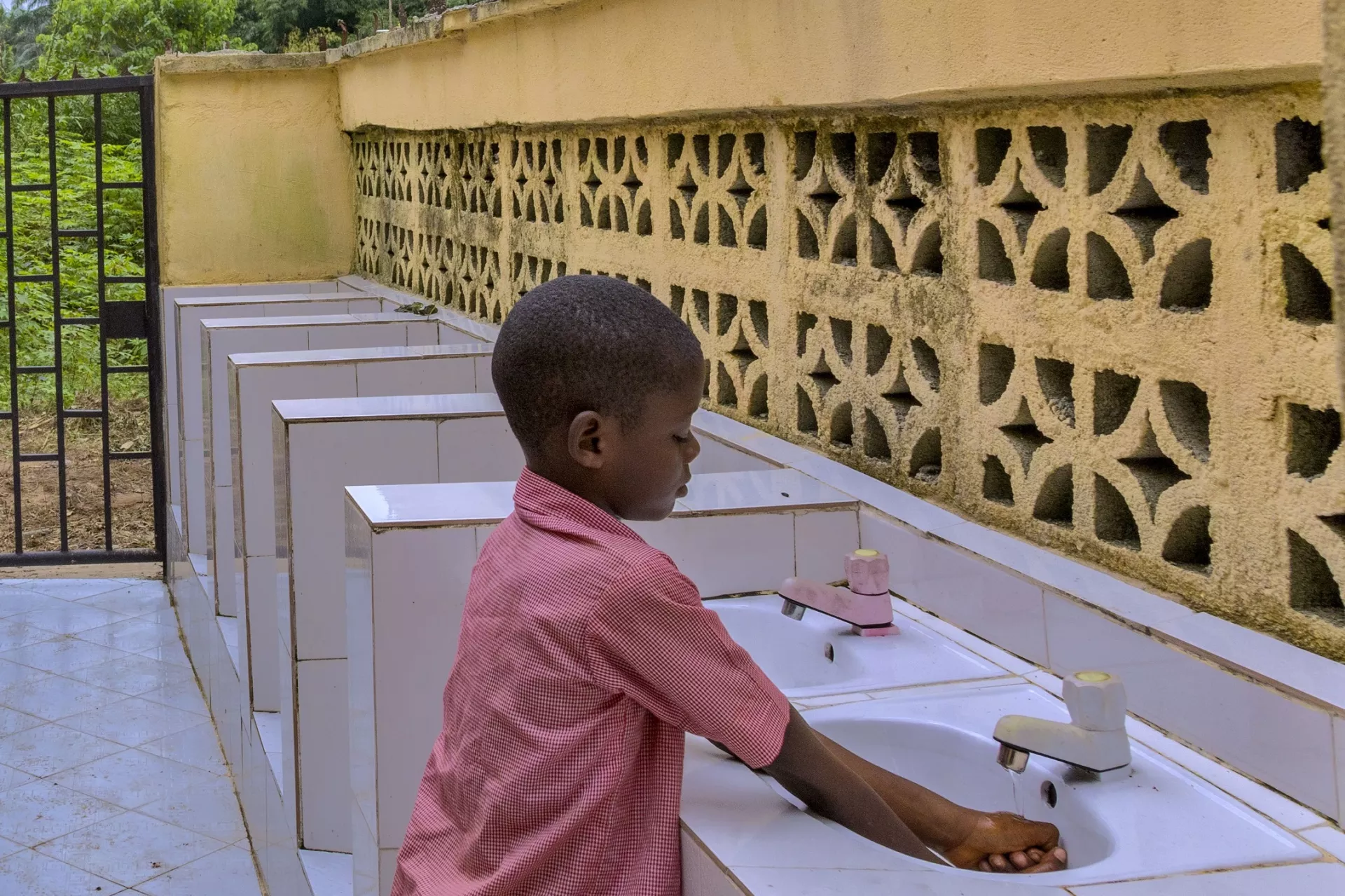 Schoolboy washing his hands