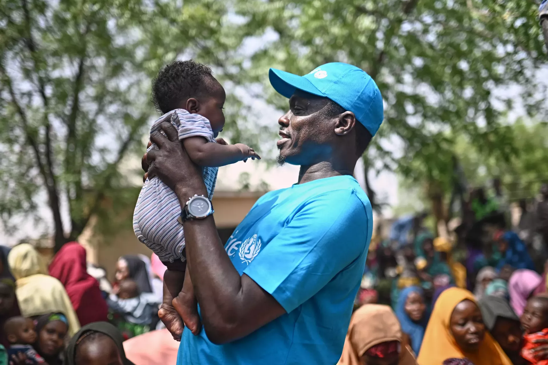 A man holding a baby in his hands. 