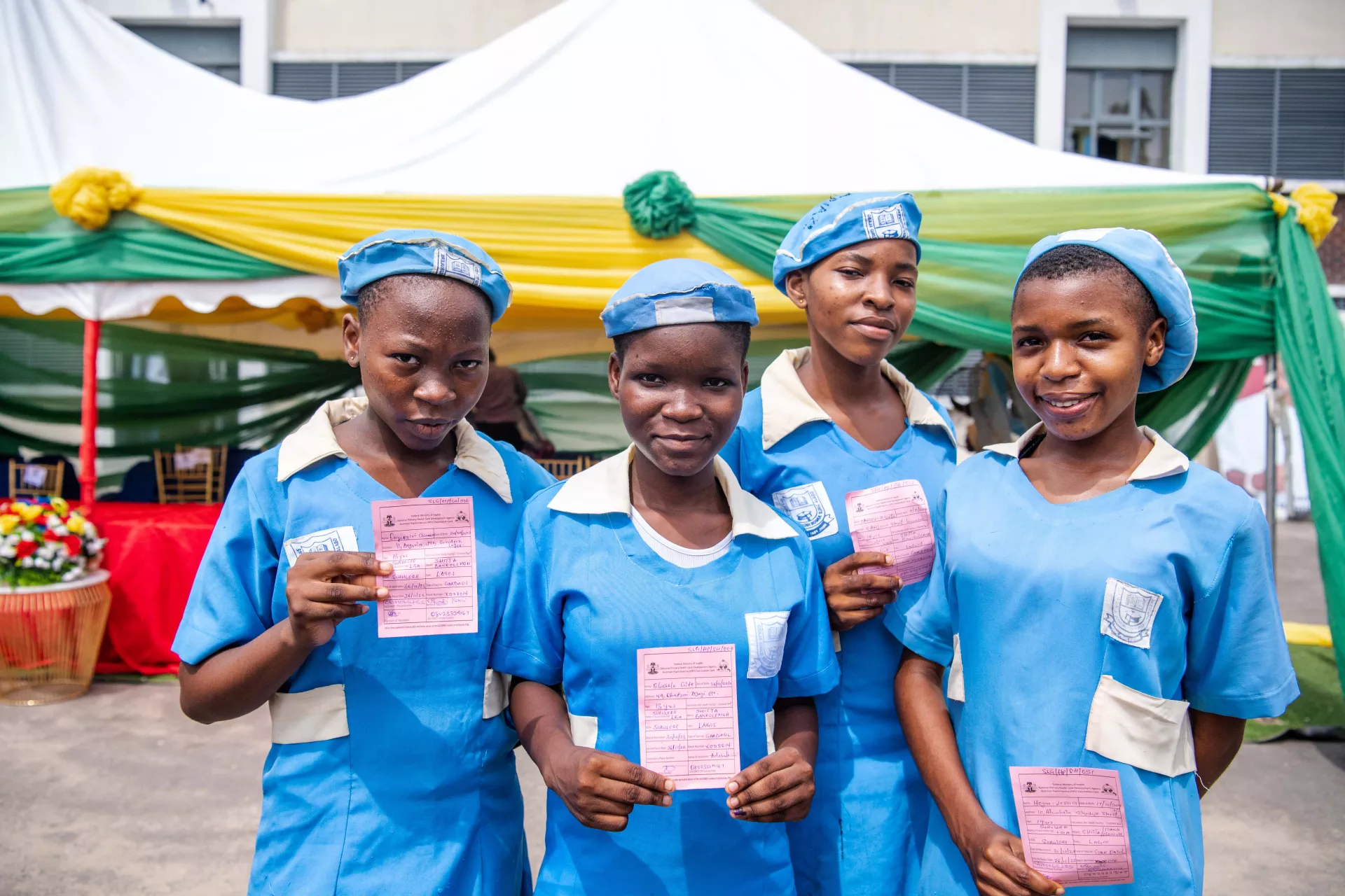 Girls holding their vaccine cards
