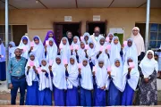 A group of students poses for a photo with their vaccination cards