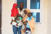 A family standing in front of a health centre