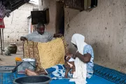 Muhammed folding clothes while his wife breastfed