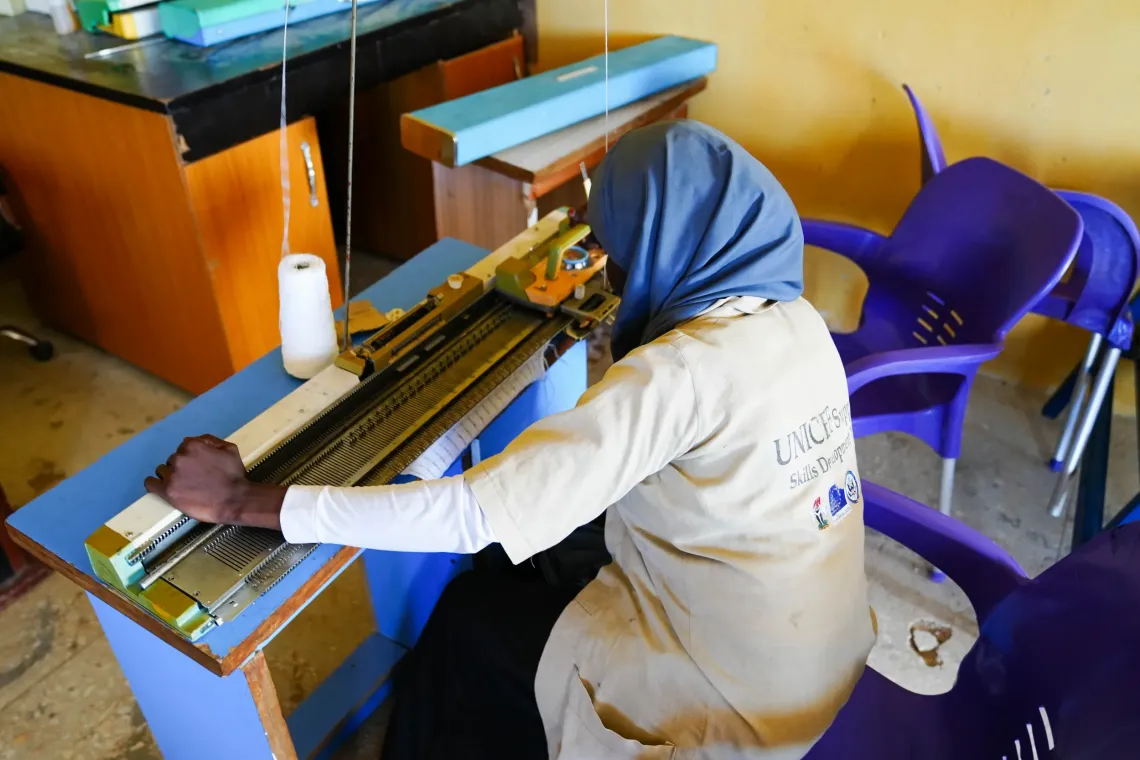 A girl operating a knitting machine