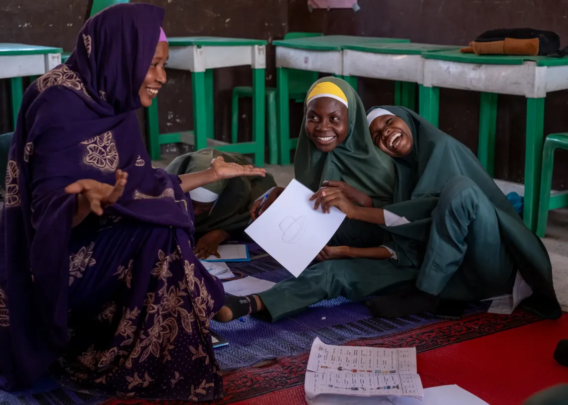 Two girls and a teacher in class.