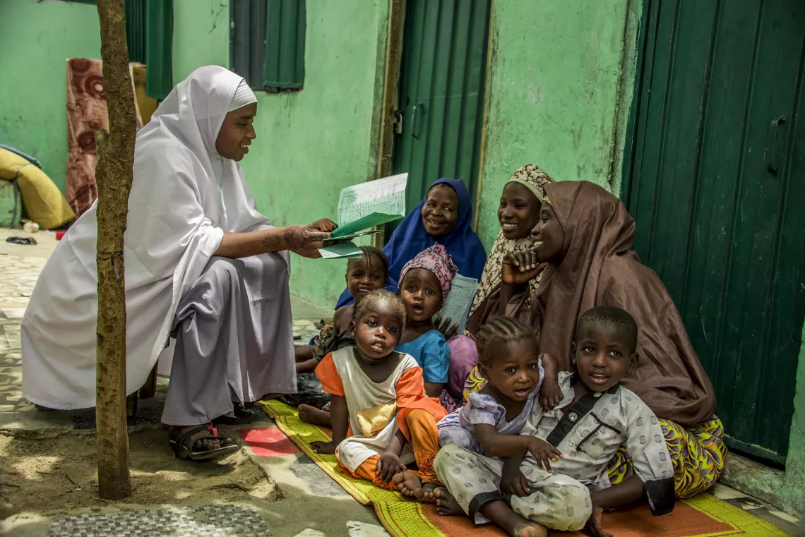 A health worker teaching mothers about immunization