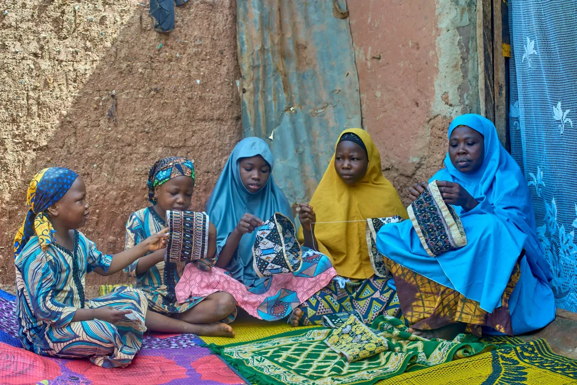 A mother and her daughters knitting.