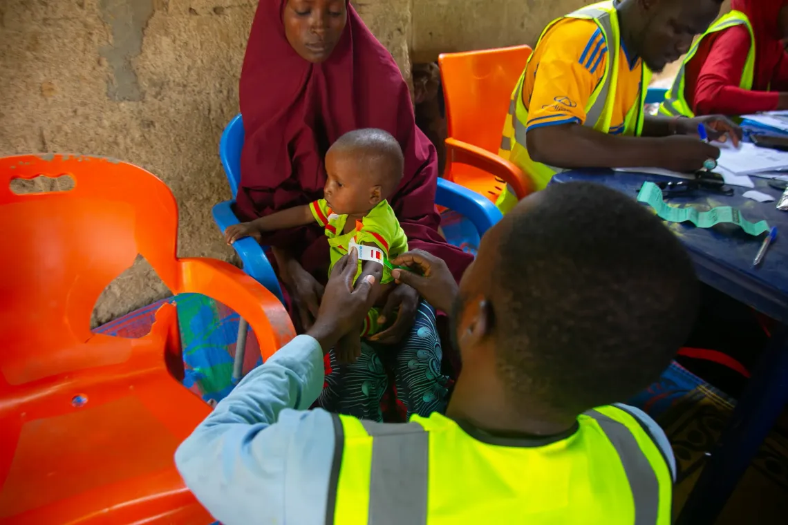 A health worker screening a child