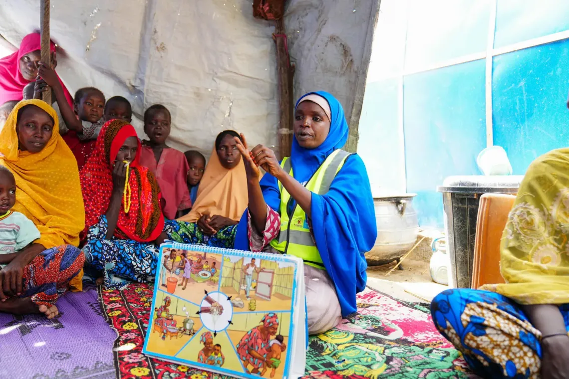 Amina Ali, a member of the CATI Team, orients families on good hygiene practices at RRR Camp, in Monguno, Borno State.