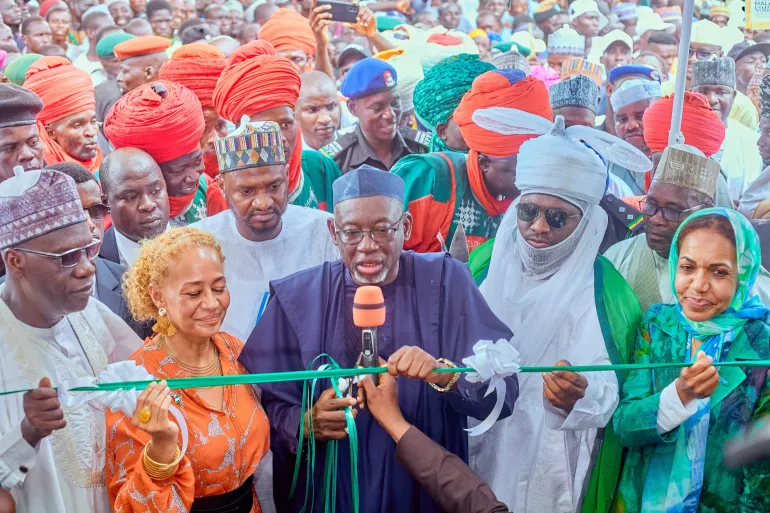 A group of people cutting ribbon