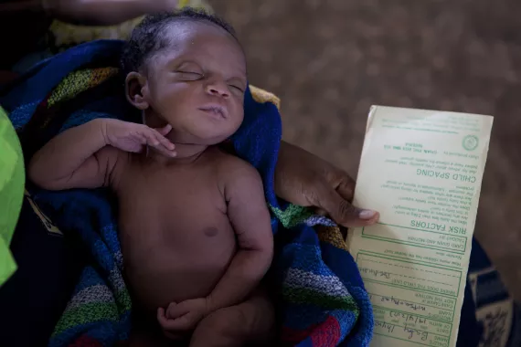 A baby with a birth registration card