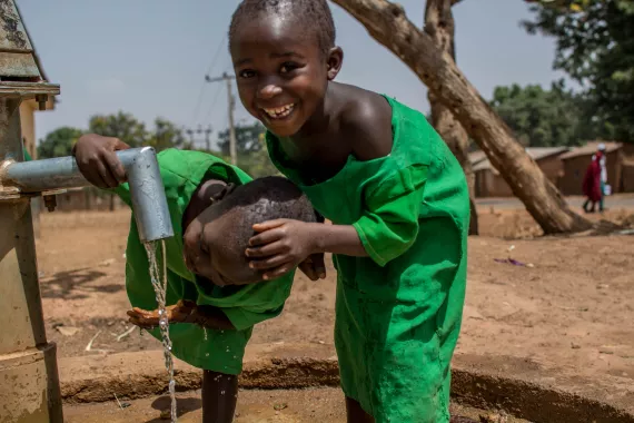 Two schoolgirls at a water facility provided by UNICEF at their school.