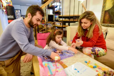 Babai, n&euml;na dhe nj&euml; vajz&euml; duke luajtur loj&euml;ra tavoline