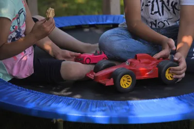 Two children play on a trampoline. 