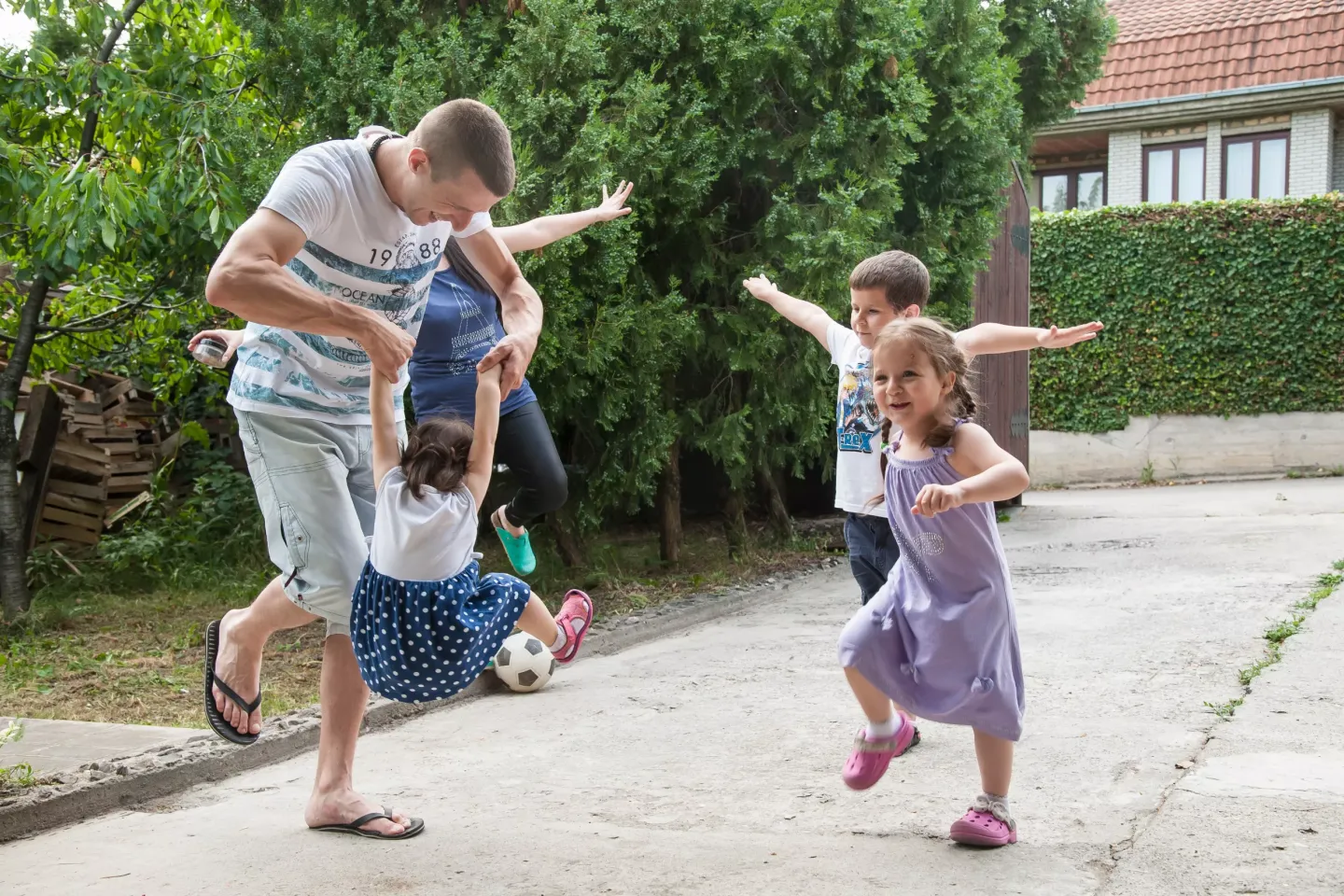 Family playing outside: a father, mother, two girls and a boy.