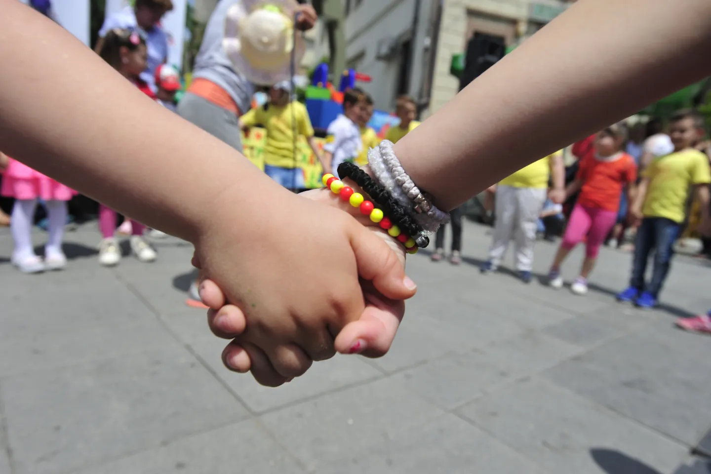 Close up image of the hands of two children holding each other's hand