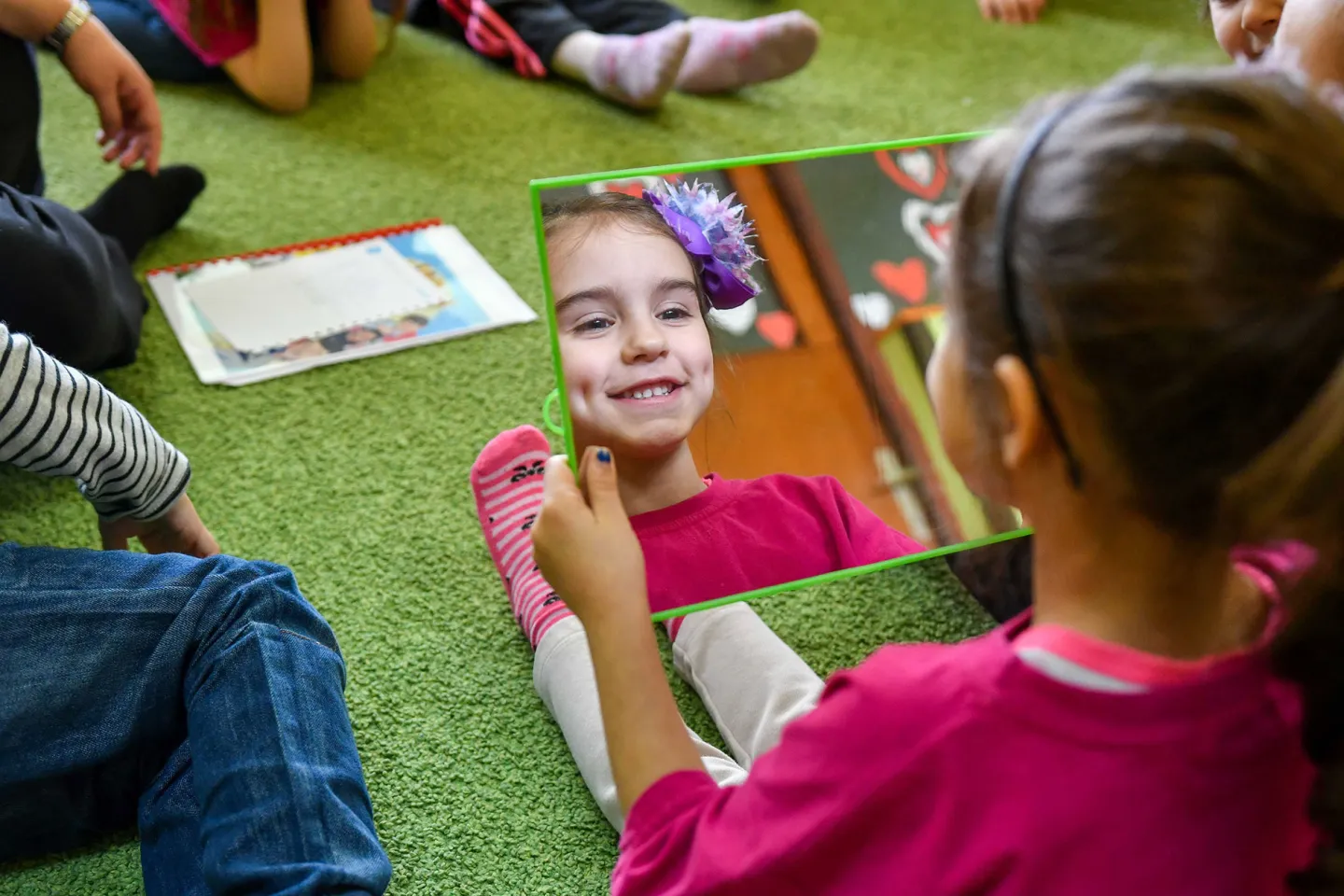 Girl smiling while looking at a mirror