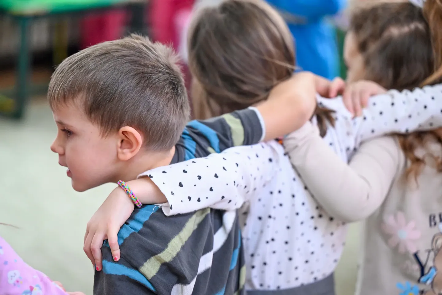 Children in kindergarten hugging each other. 