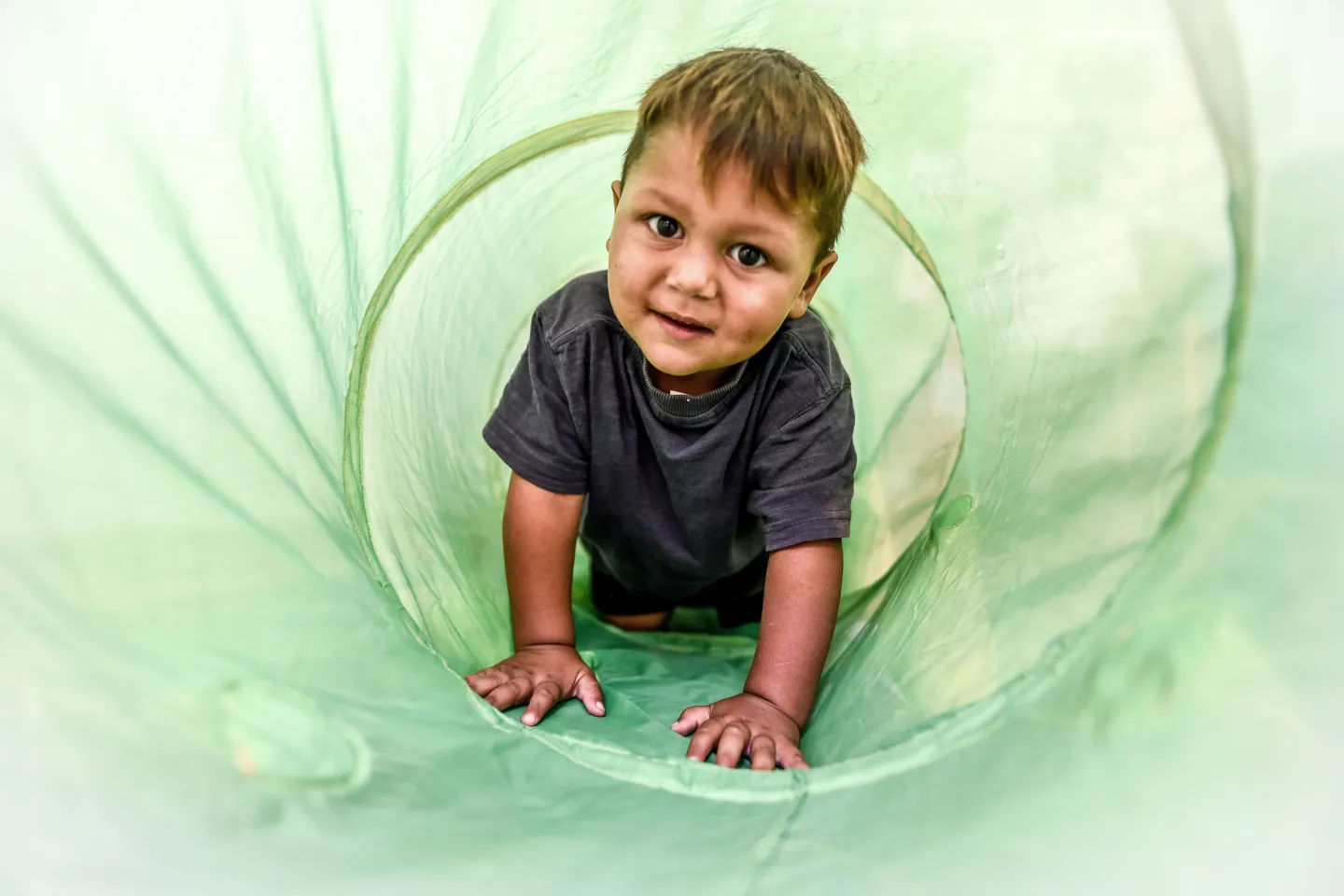 A child reaching out from a caterpillar tunnel 