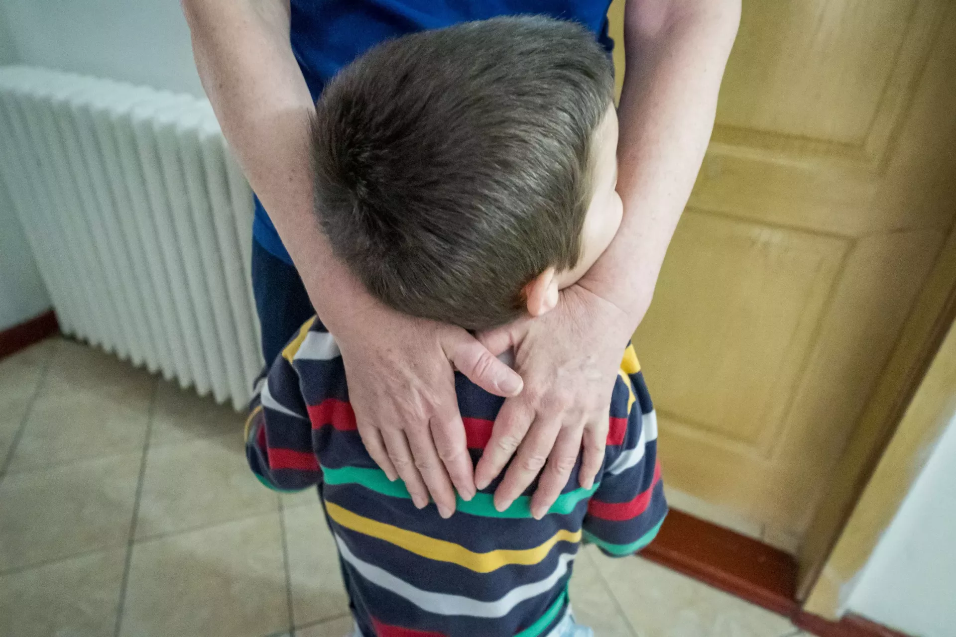 Adult person hugging boy