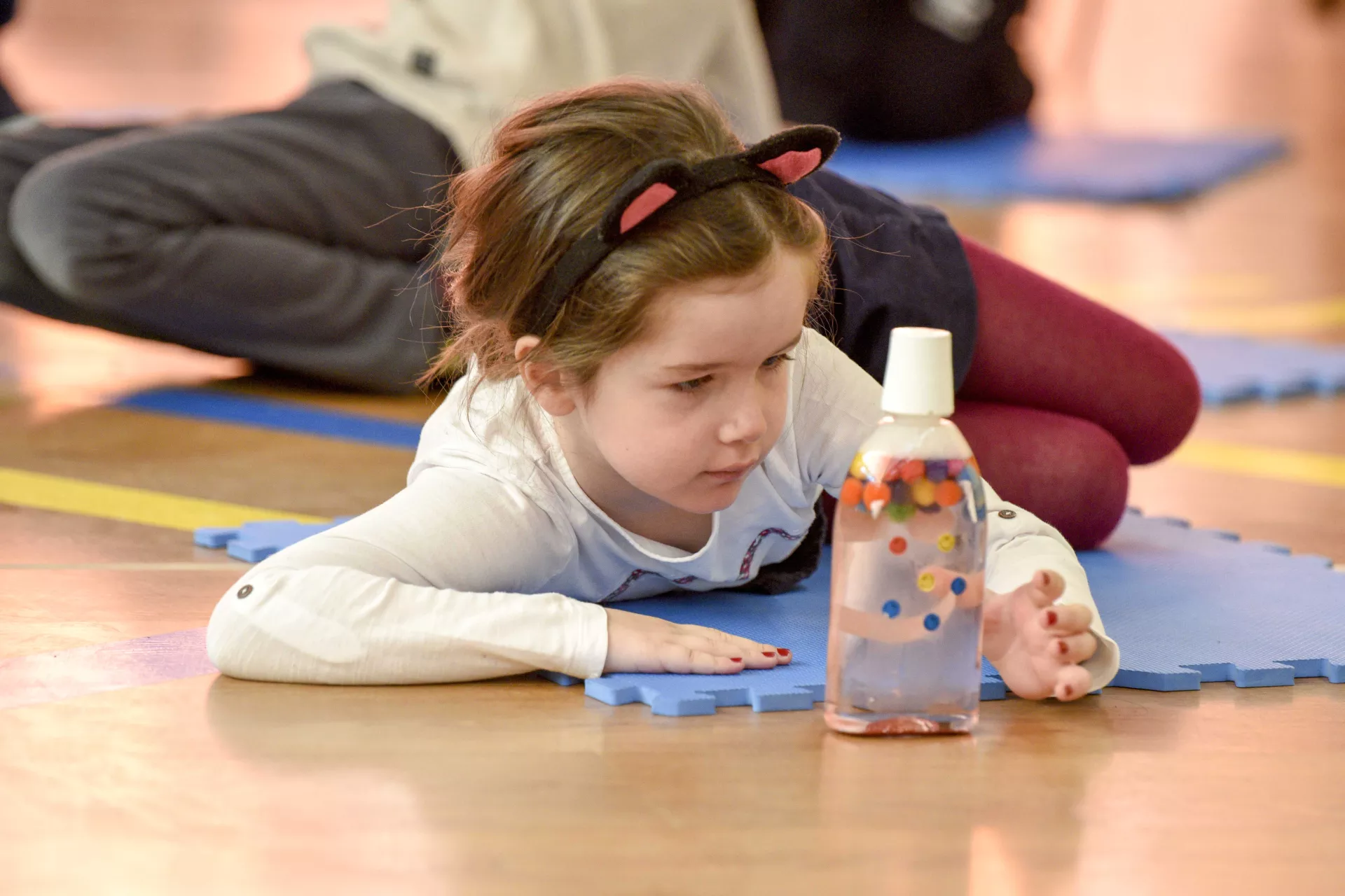 A girl looking at a diy sensory bottle