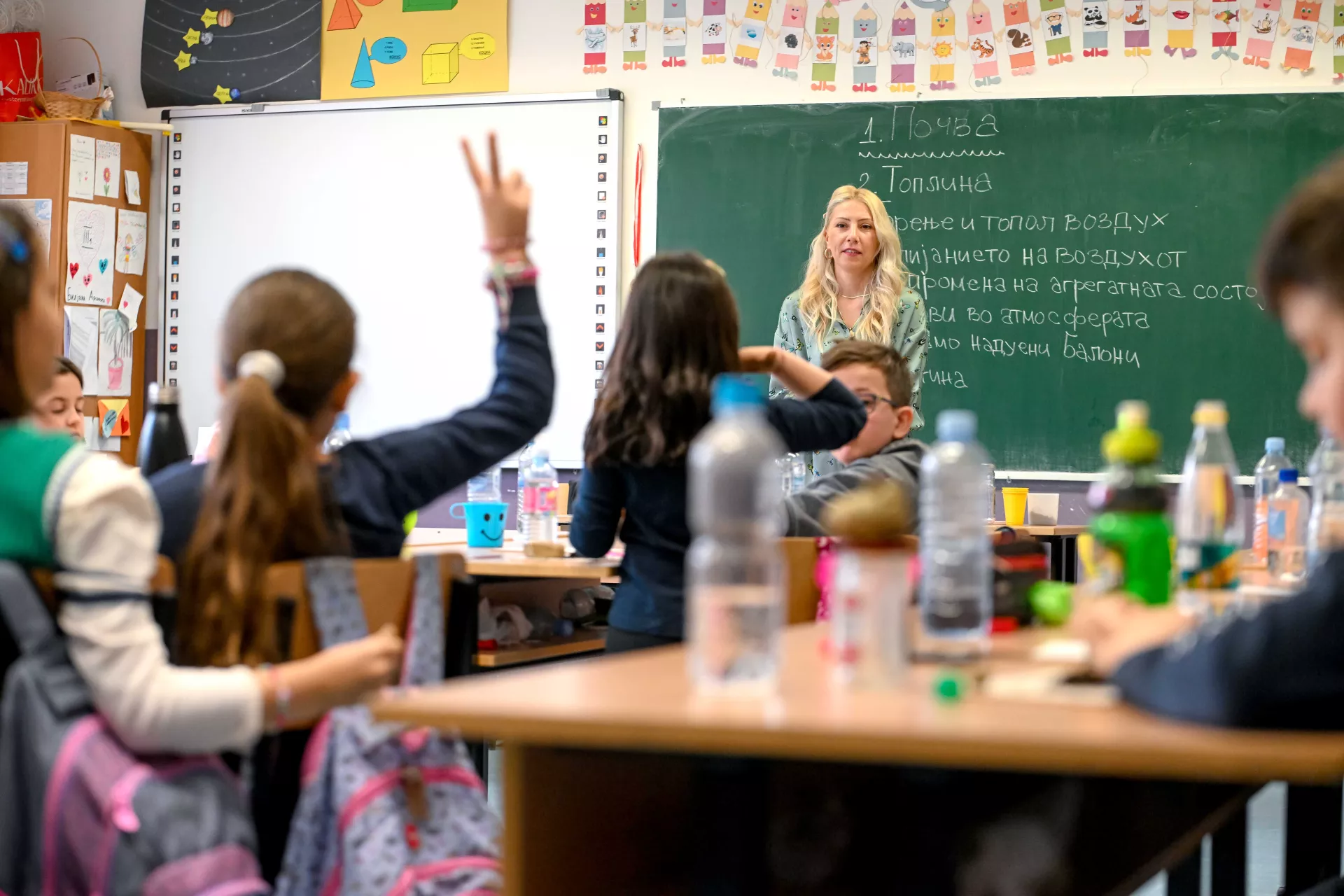 Child raising hand in classroom 