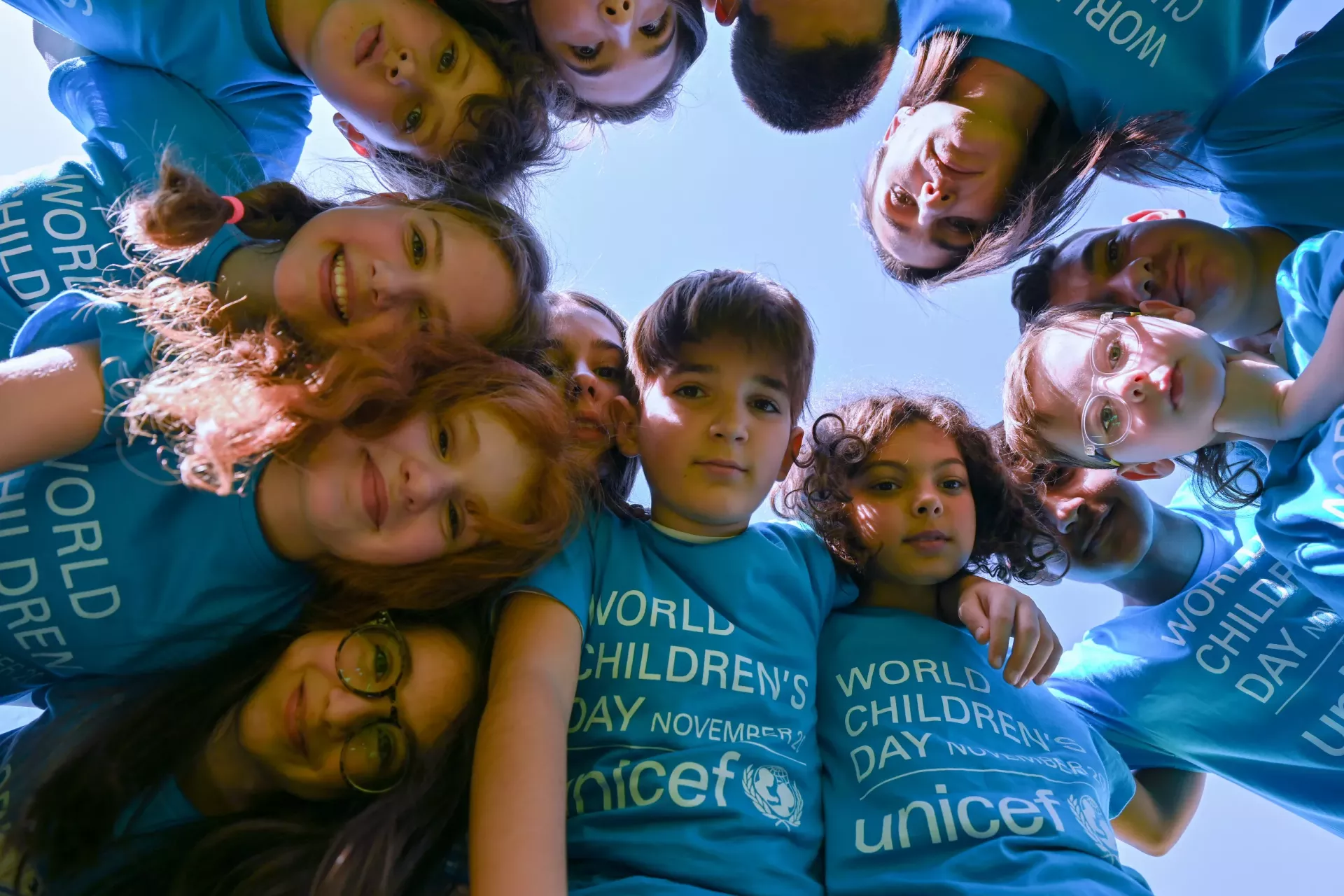 Team photo of a group of children hugging and wearing blue t-shirts 