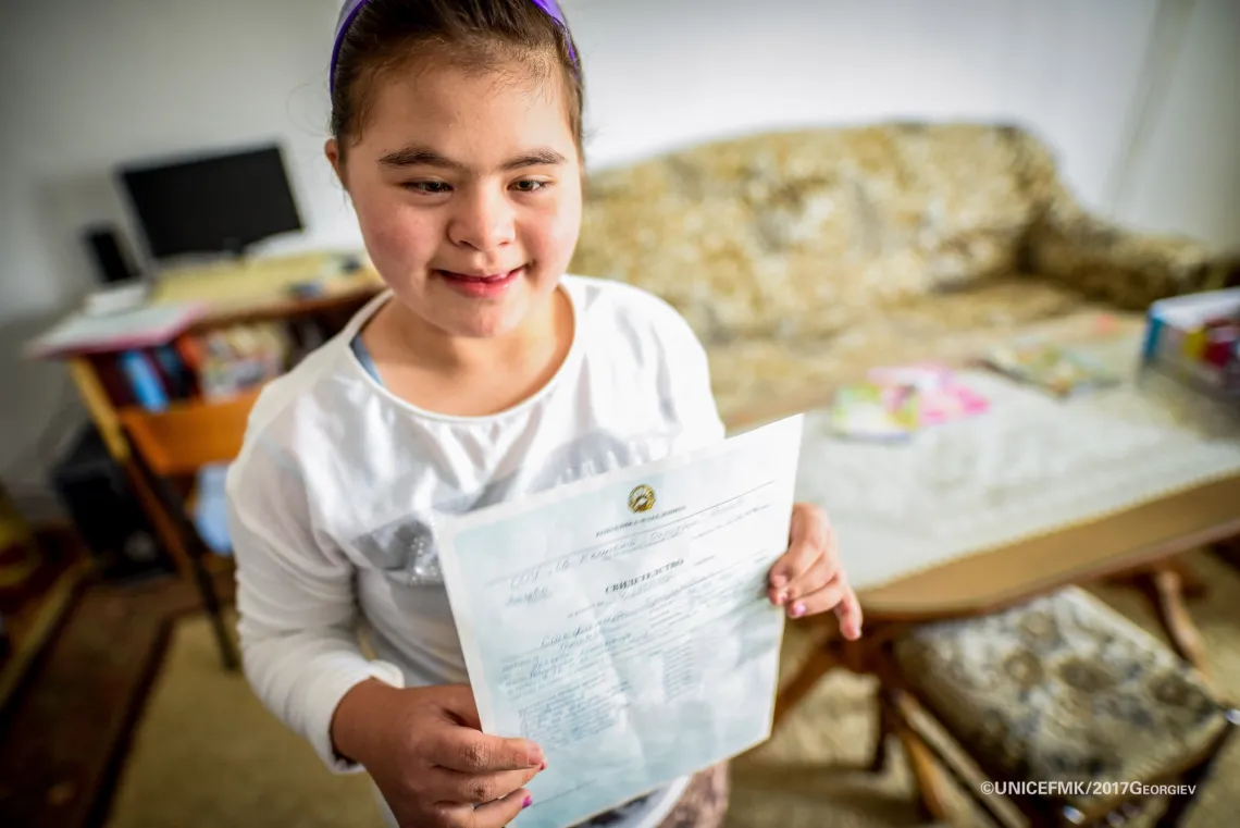Stefanija 12 year old girl with down syndrome proudly presents her straight A's report card from school