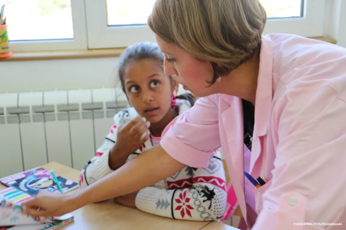 Class teacher Suzana explains the new lesson to one of the girl students in her class
