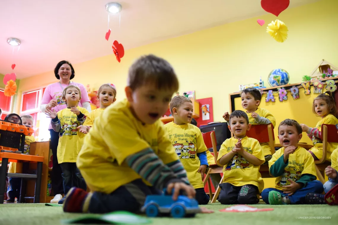 Four-year-old Mihail who has cerebral palsy plays with a blue toy car in kindergarten 