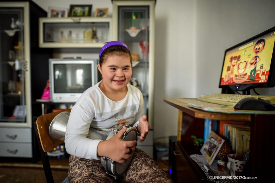 Stefanija 12 year old girl with down syndrome plays darabouka in the living room of her family house in Delcevo