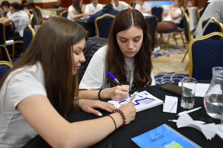 Two adolescent girls drawing a sketch in a notebook, UPSHIFT workshop
