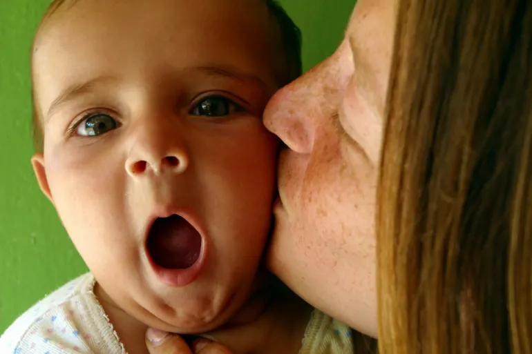 Mother kissing her baby on the cheek 