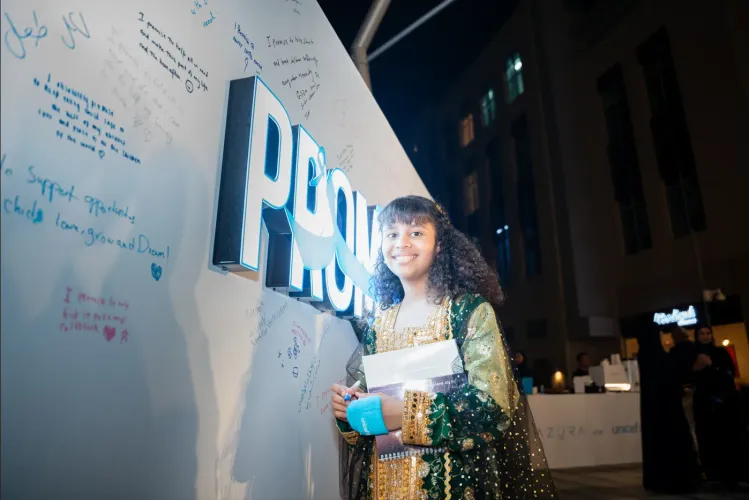 girl in front of the promise wall