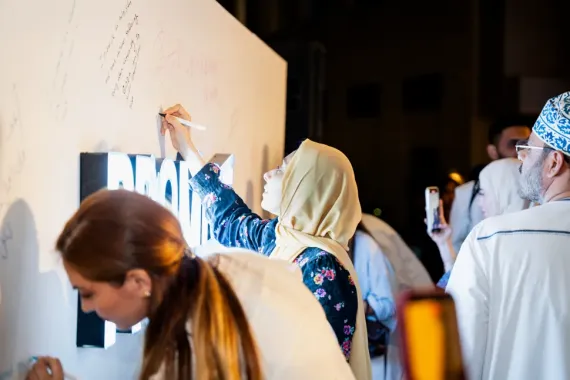 People writing on the promise wall