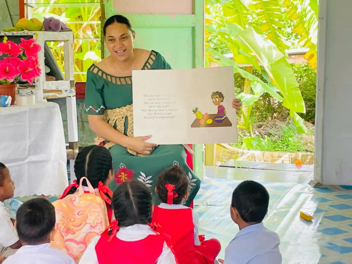 ECE teacher holds the inclusive ECE storybooks and reads to her children, Tongatapu, Tonga