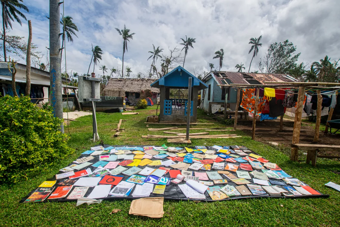 Drying up school books that got wet during the cyclone.