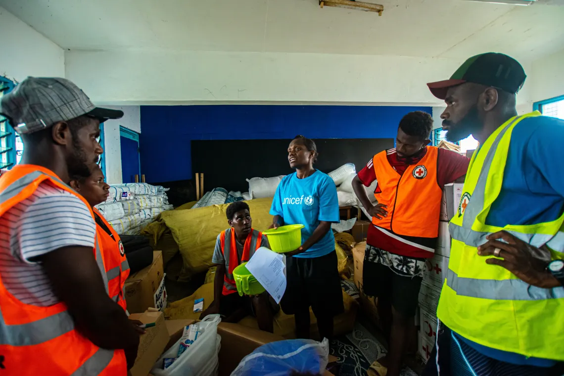 Sandrine, UNICEF WASH Officer explains to Red Cross volunteers contents of the emergency supply kits.
