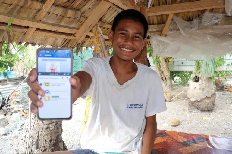 Betangnga Nantei, 12, smiles with a mobile phone showing his favorite science lesson on Learning Passport