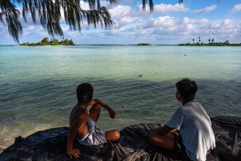 A goal post stands submerged during high tide on a beach in Tarawa, Kiribati.