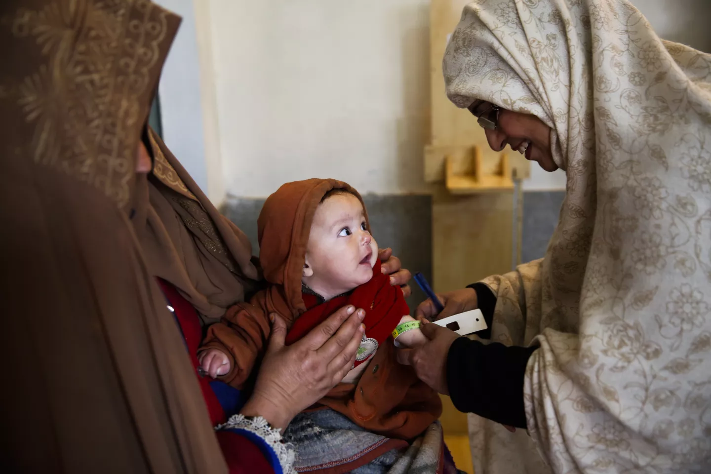 An infant having his mid-upper arm circumference measured