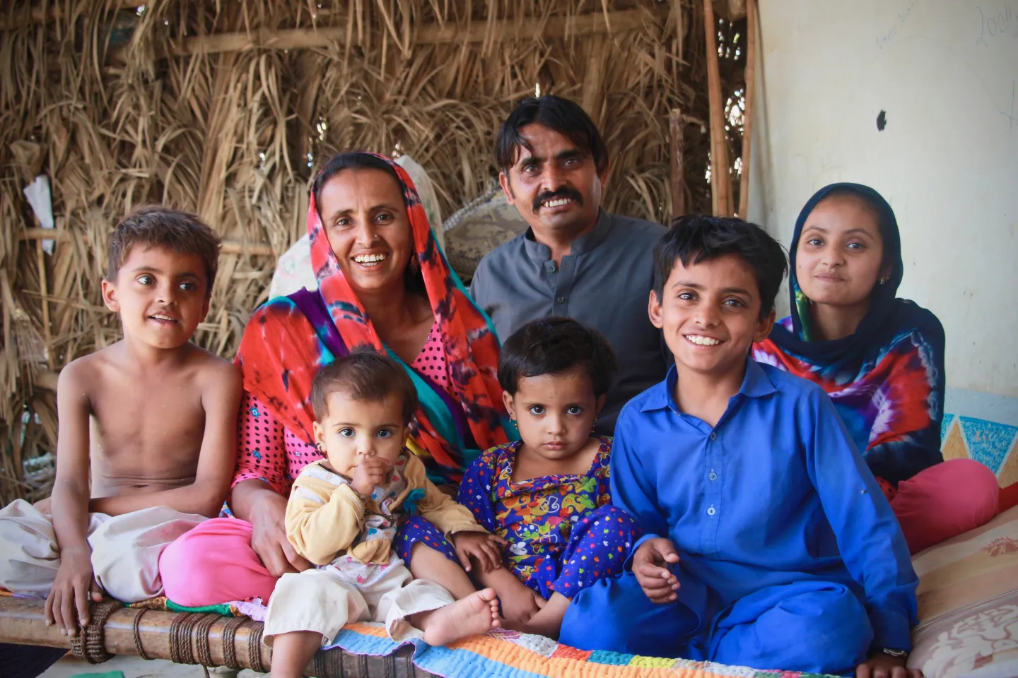 A village family from Sindh province, Pakistan looks at the camera as they enjoy some family time on a hot summer day.