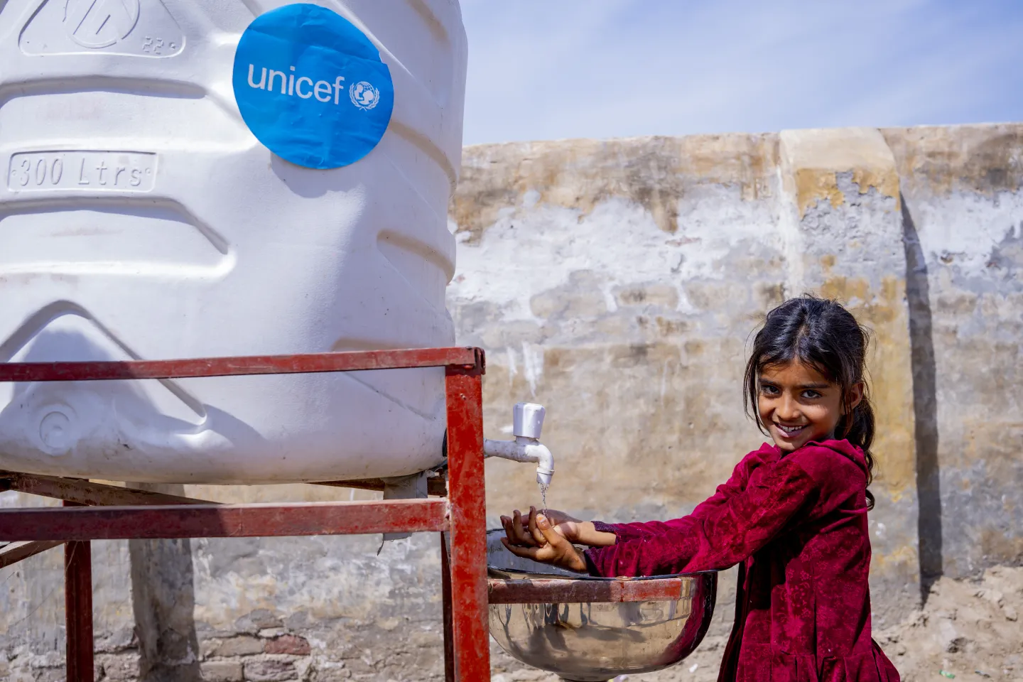 A girl washes her hands at a at a handwashing station established by UNICEF in Mehar Veesar village, Khairpur district, Sindh.