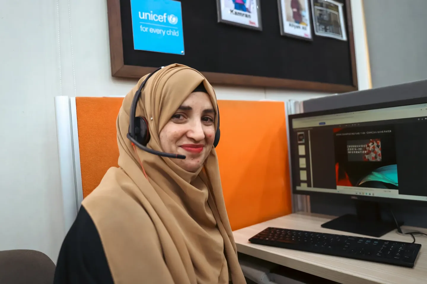 A Sehat Tahaffuz Helpline agent sits at her desk, ready to listen and respond to families seeking trusted health guidance.