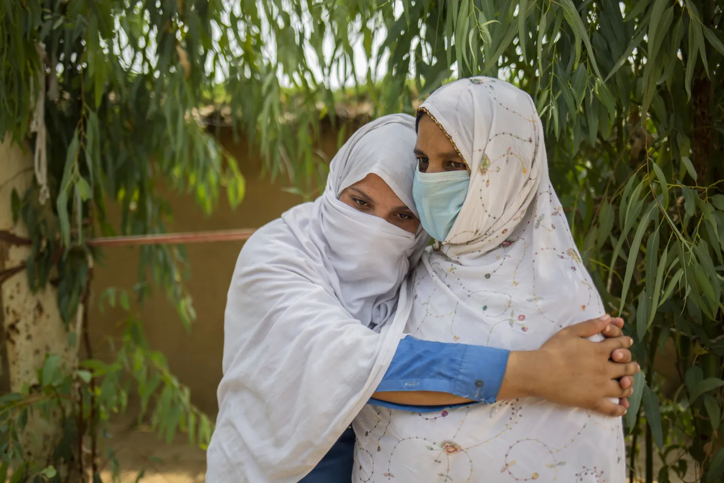 Aqeela (14) embraces her mother, Bus Bibi in the courtyard of their home.