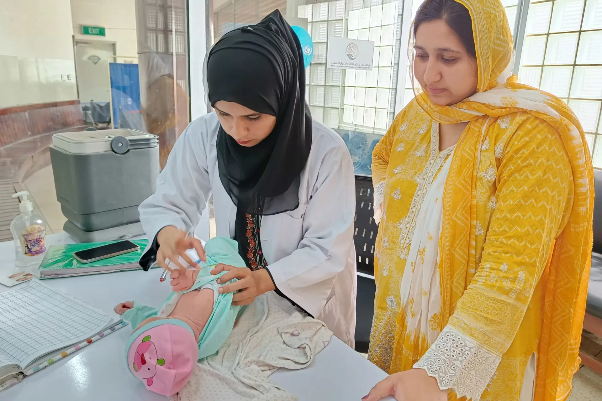Vaccinator Ayesha administers BCG vaccine to the newborn baby boy Saim.