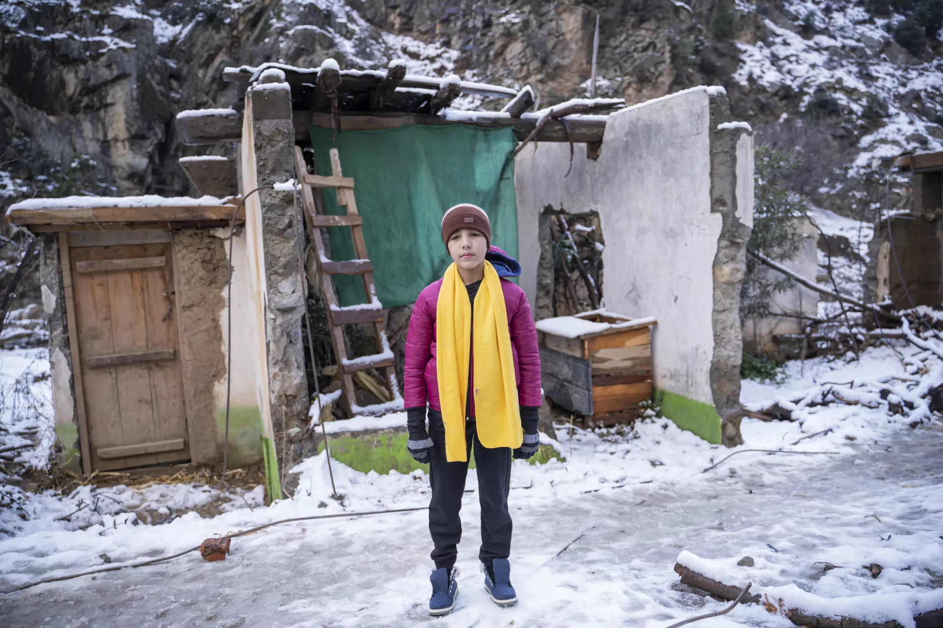 Noorullah stands in front of his damaged house in Sulool Daramdala village, Upper Dir District, Khyber Pakhtunkhwa.