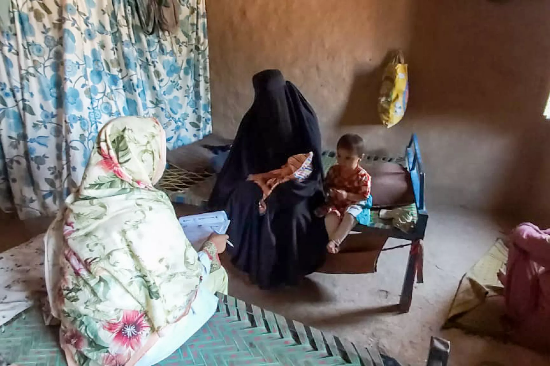 A Lady Health Visitor provides Gulsanga with postnatal  counselling at home.