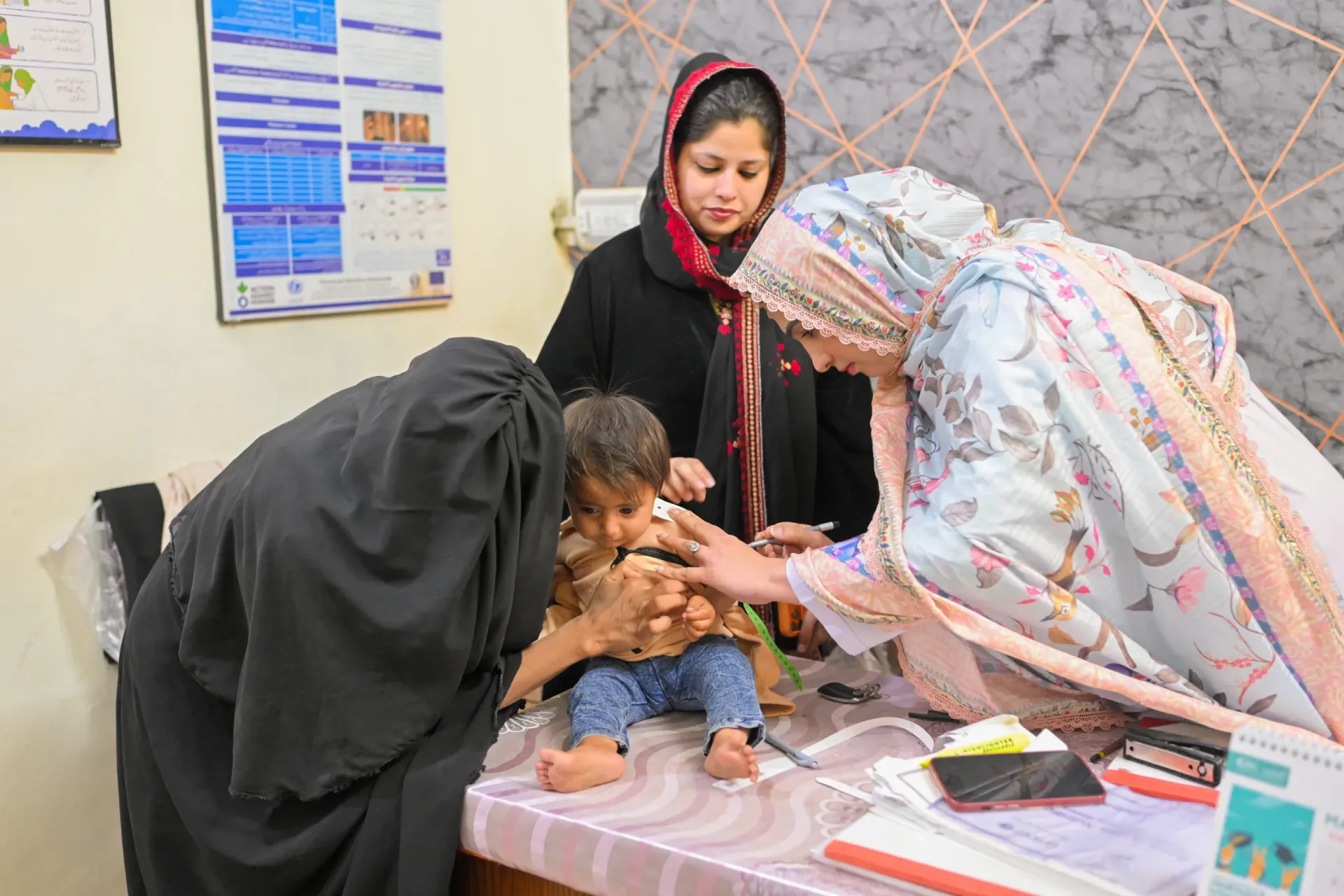 Nutrition Assistant Farwa measures the mid-upper arm circumference (MUAC) of 18-month-old Sufiyan at Shaheed Benazir Bhutto Hospital in Quetta, Balochistan.