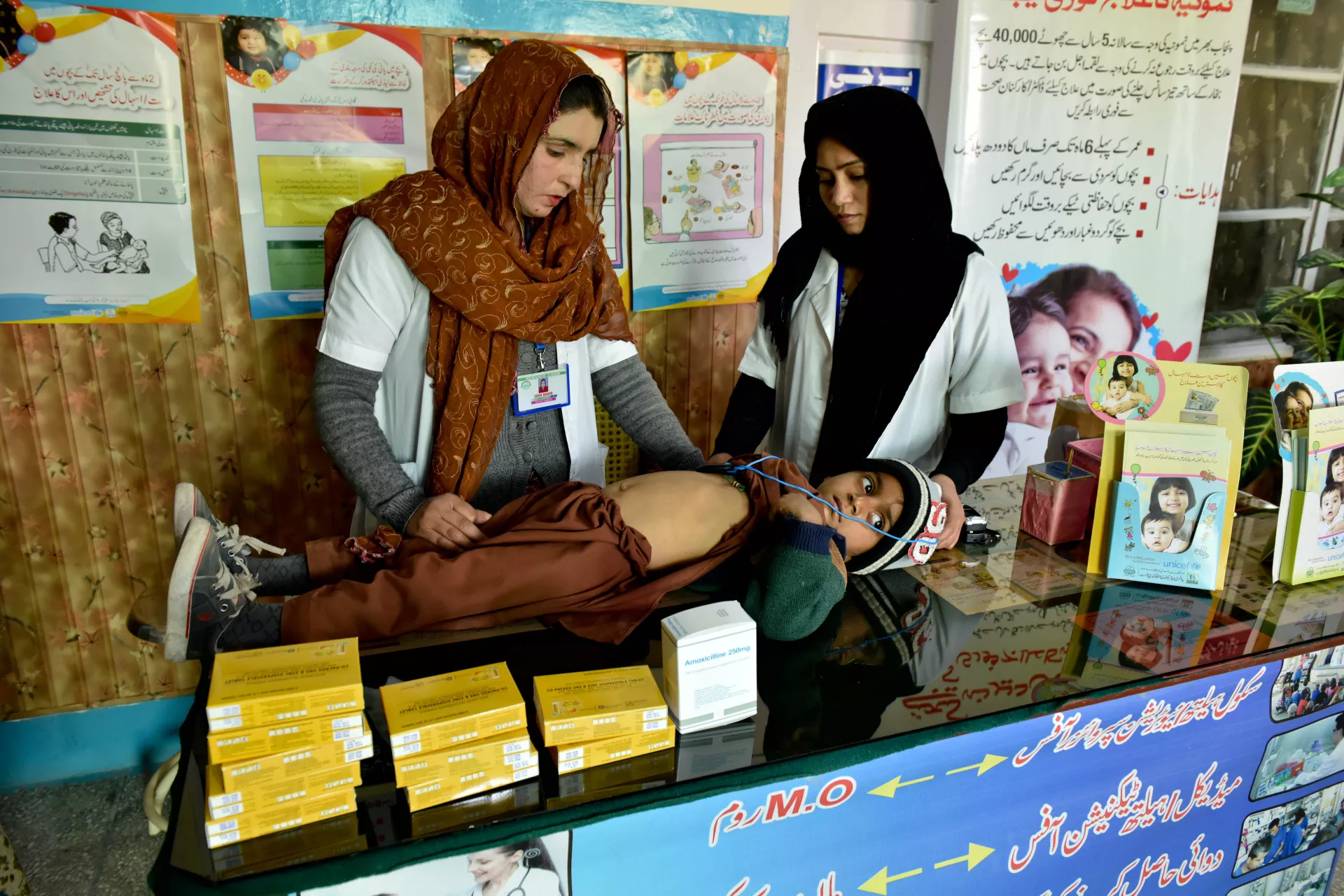 Lady health workers assessing a child at the Basic Health Unit in Bahawalnagar District