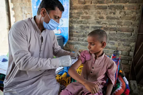 A boy receives an injection at a medical camp for flood affected people in Sindh